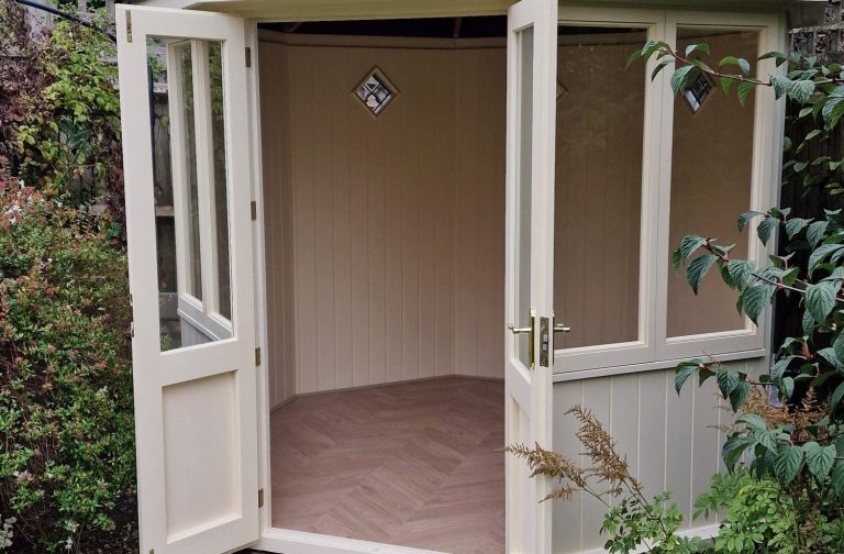 Interior of a medium sized, empty octagonal Summerhouse with open double doors.