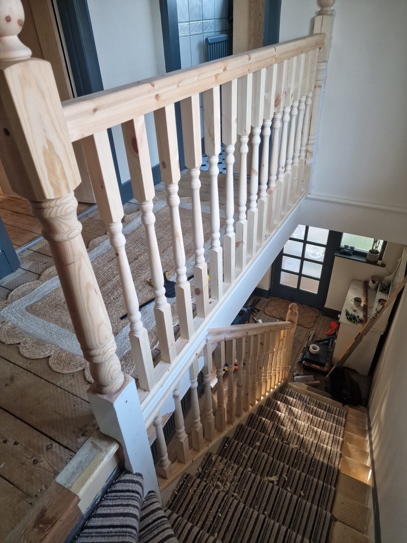 View from a staircase railing looking down towards a hallway and entrance.