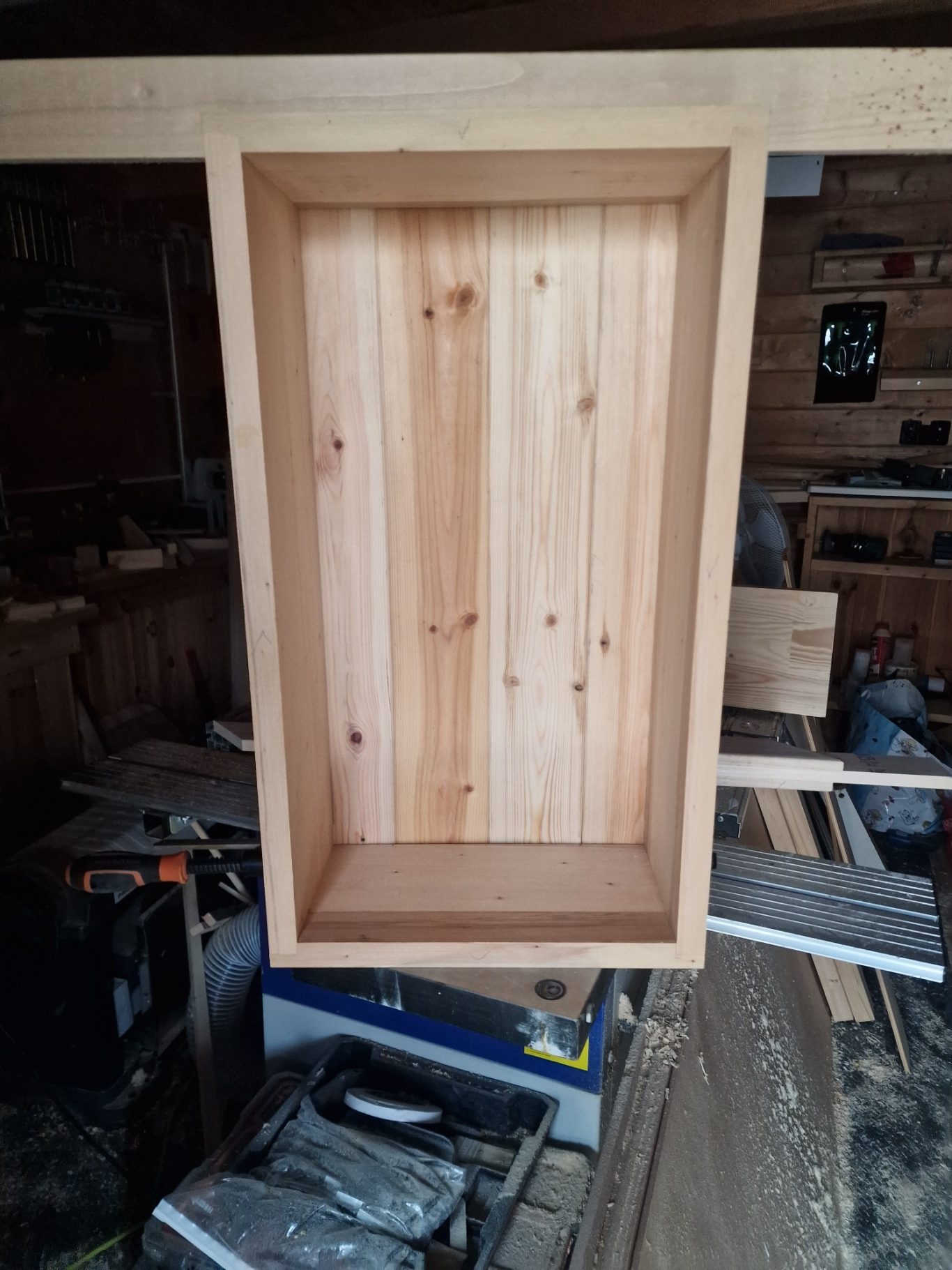 Wooden cabinet with an open space, featuring a natural wood grain finish.